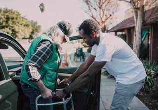 Man assisting elderly person