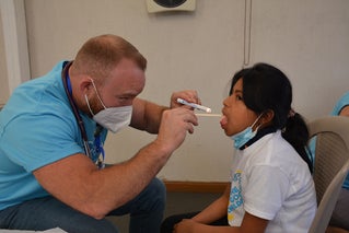 volunteer doctor examining child
